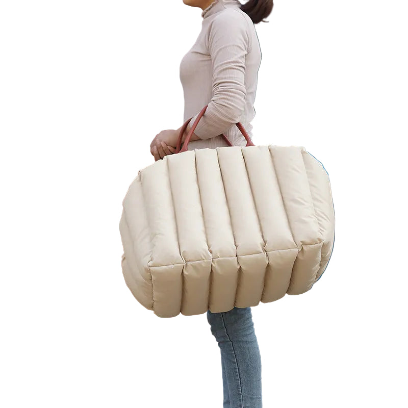 Woman carrying a light khaki luxury dog carrier bag and travel bed for comfortable travel with a small pet