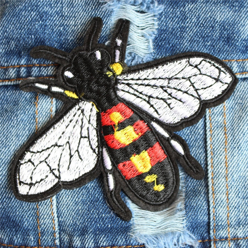 Detailed view of bee embroidery on a fashionable denim dog jacket for small dogs