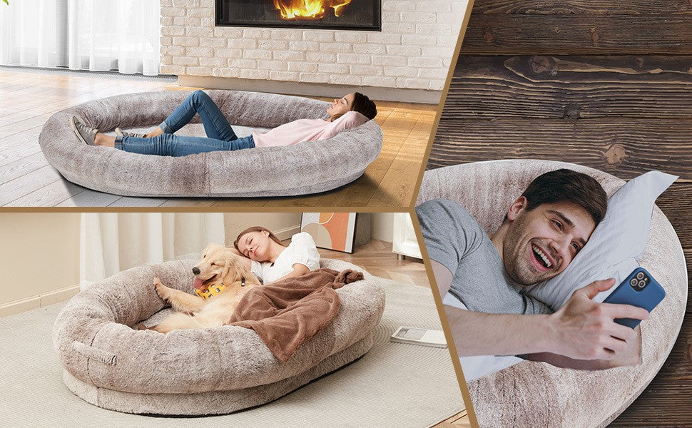 Dog and owner comfortably lying together on an oversized human dog bed with plush calming cushioning for relaxing and movie nights